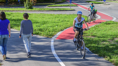 Radfahrer und Fußgänger auf einem Fuß- und Radweg Radfahrer und Fußgänger auf einem Fuß- und Radweg