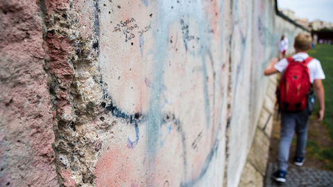 Die Berliner Mauer Junge geht an Resten der Berliner Mauer entlang