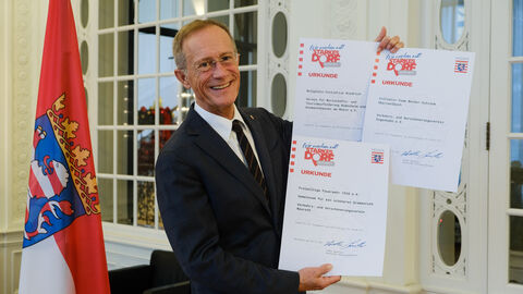Chef der Staatskanzlei mit Urkunden zur Auszeichnung "Starkes Dorf"