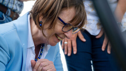 Ministerin Hinz betrachtet Steinkauzküken.