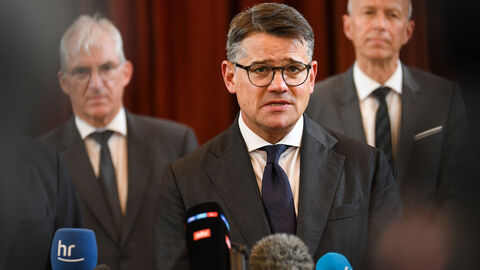 Ministerpräsident Boris Rhein in Bad Arolsen Ministerpräsident Boris Rhein steht, flankiert von anderen Menschen, vor Mikrofonen diverser Medien.