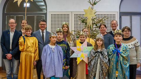 Eine Gruppe Sternsinger mit Ministerpräsident Rhein und Staatsminister Wintermeyer Eine Gruppe Sternsinger mit Ministerpräsident Rhein und Staatsminister Wintermeyer in der Staatskanzlei, sie halten Schilder in der Hand