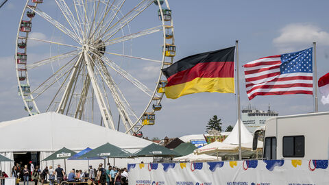 Riesenrad, amerikanische und deutsche Flagge im Wind Riesenrad, amerikanische und deutsche Flagge im Wind