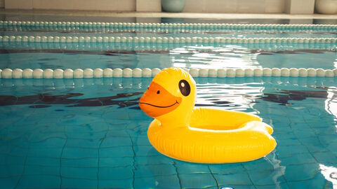 Schwimmen wie eine Ente Ein Schwimmreifen in Form einer gelben Ente