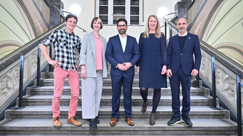 Fün Personen stehen auf einer Treppe zum Gruppenbild aufgestellt. In der Mitte steht Wirtschaftsminister Mansoori.