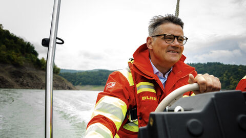 Ein Mann in rot-gelber Kleidung auf einem Boot.