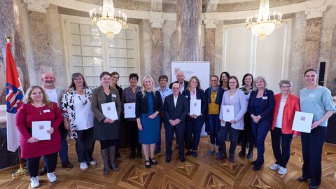 Eine Gruppe von Menschen steht vor der Kamera.