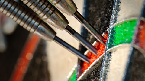 Perfekte Aufnahme an einer Dartscheibe in der Nahaufnahme Perfekte Aufnahme an einer Dartscheibe in der Nahaufnahme