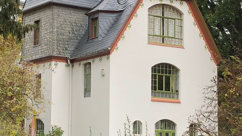 Die Villa Stosch von außen, ein weißer Villenbau mit grauem Dach