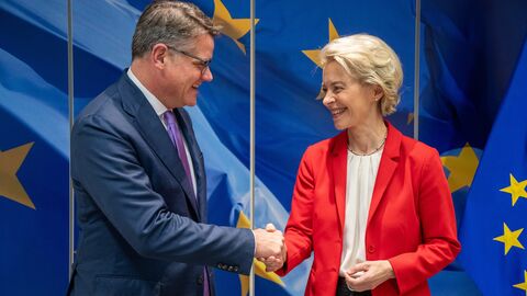 Ministerpräsident Rhein schüttelt Ursula von der Leyen die Hand, beide lächeln. Dahinter ein Bild einer Europa-Flagge.