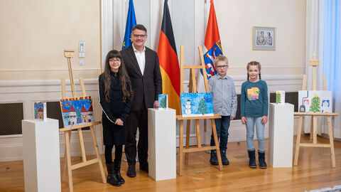 Ministerpräsident Boris Rhein und die Gewinnerinnen und Gewinner Sara, Sonja und Felix Ministerpräsident Boris Rhein und die drei Kinder, die den Malwettbewerb gewonnen haben