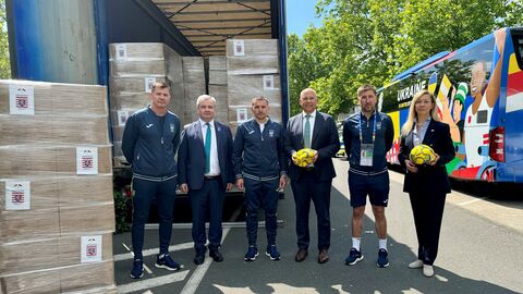 Innenminister Roman Poseck, Generalkonsul der Ukraine Vadym Kostiuk und Frau Dr. Viktoriia Nikolaevna Freifrau von Rosen stehen mit Teilen des Teams der ukrainischen Nationalmannschaft vor dem Hilfstransport.
