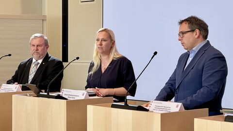 Zwei Männer und eine Frau stehen jeweils an einem Rednerpult.